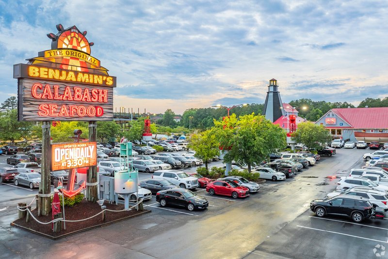 Benjamin’s Calabash Seafood restaurant sign and busy parking lot at dusk in Calabash, NC