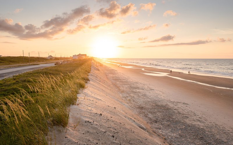 Sunset along Topsail Island beach with glowing sky and shoreline near Hampstead, NC