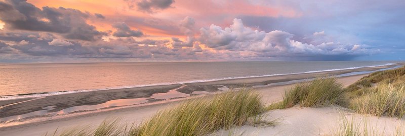 Wide sandy beach with gentle surf and coastal horizon in Hampstead, NC