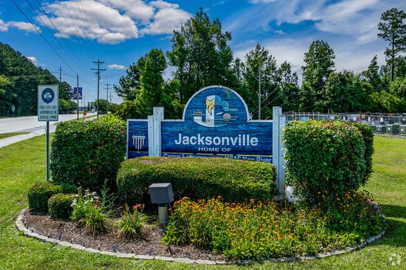 A large town sign and roadside feature in Jacksonville, NC.