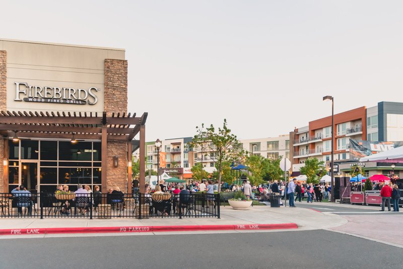 Dining and street activity at Park West Village in Morrisville, North Carolina with Firebirds restaurant and crowds