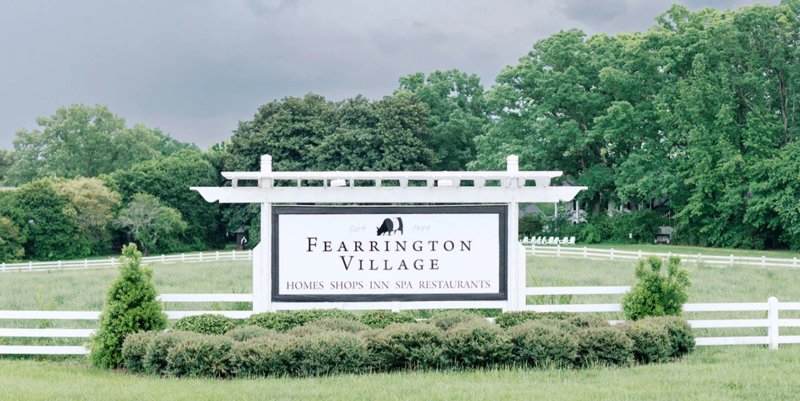 Entrance sign for Fearrington Village in Pittsboro, North Carolina with white fencing and landscaped grounds